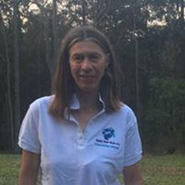 Photo of Catherine Taylor, dark brown hair, background of the Australian bush.